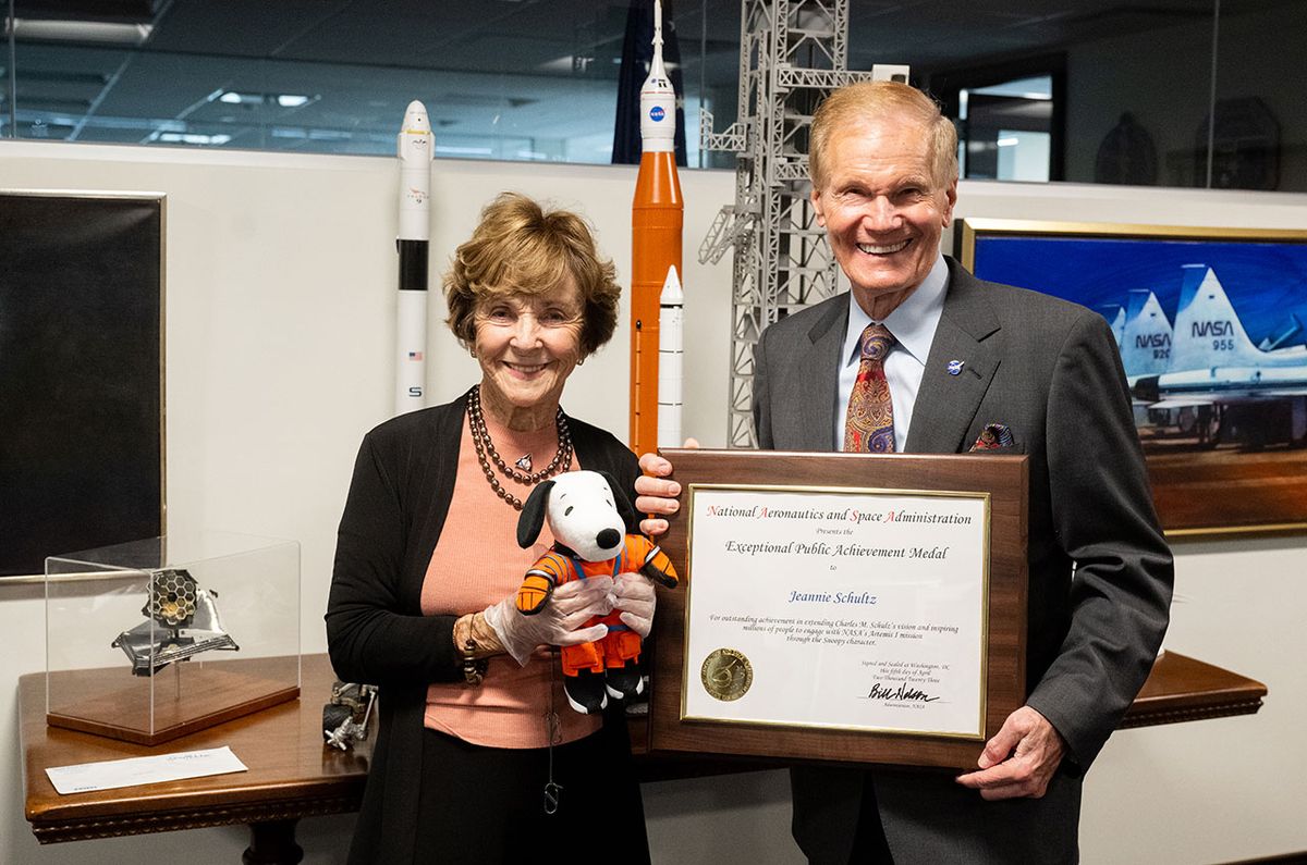 NASA Administrator Bill Nelson (right) and Jeannie Schulz, widow of Peanuts gang creator Charles M. Schulz, holding the Artemis I Snoopy zero gravity indicator pose with Schulz&#039;s NASA Exceptional Public Achievement Medal plaque on Wednesday, April 5, 2023, at NASA Headquarters in Washington, DC.