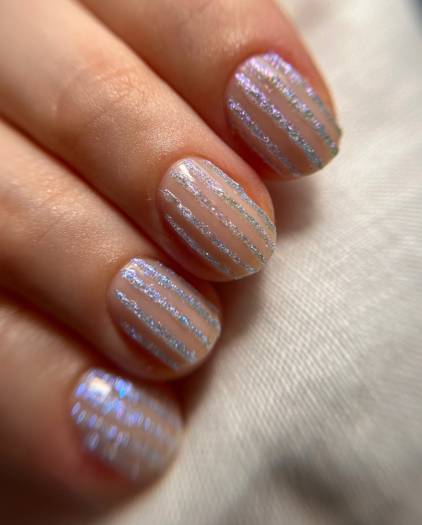 A close-up shot of a glittery stripe manicure