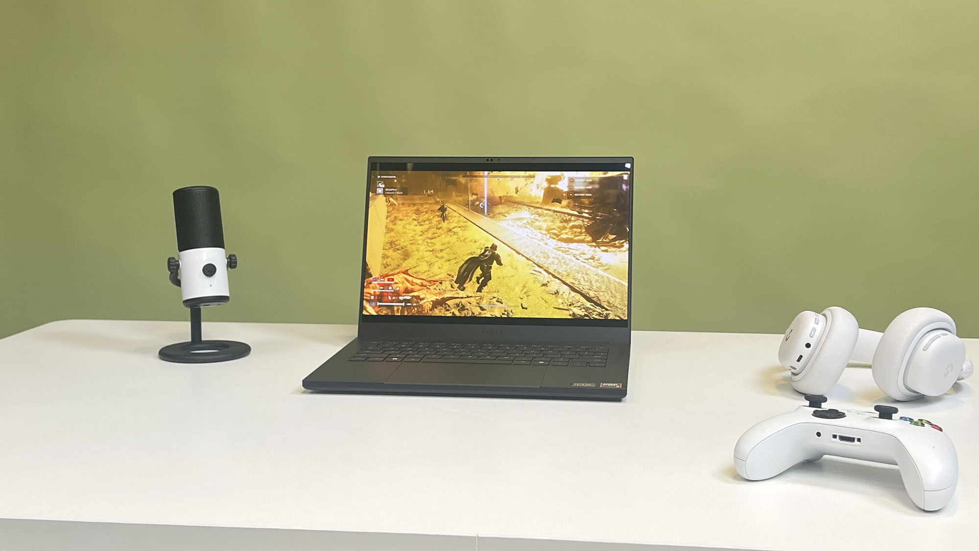 Helldivers 2 playing on a Razer Blade 14 (2025) that is surrounded by gaming peripherals