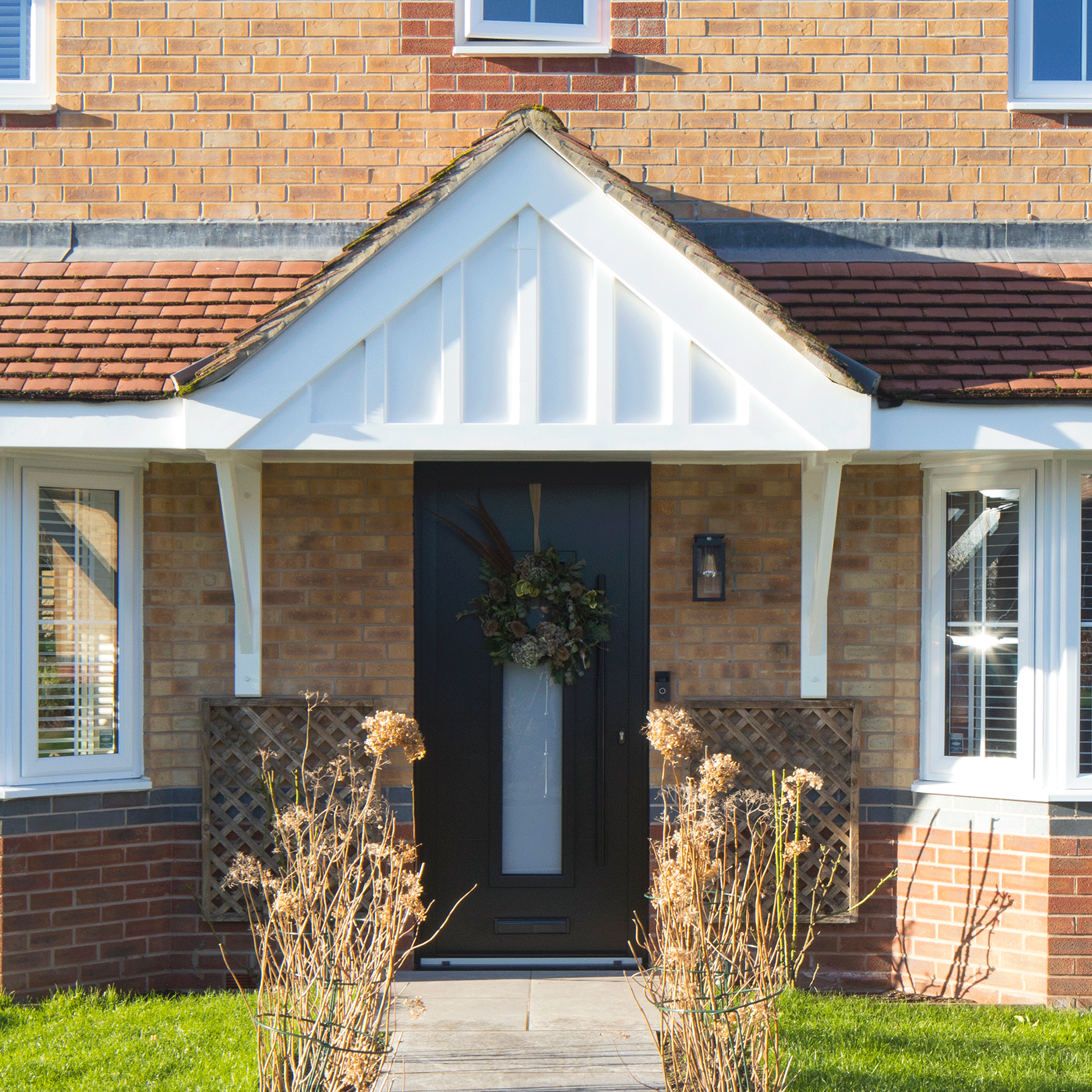 the exterior of a contemporary built house with a wreath on the front door