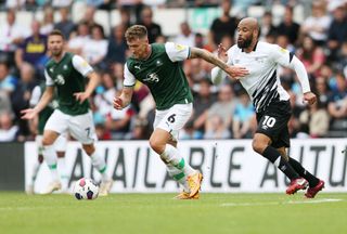 Dan Scarr of Plymouth Argyle is challenged by David Mcgoldrich of Derby County during the Sky Bet League One between Derby County and Plymouth Argyle at Pride Park Stadium on September 03, 2022 in Derby, England.