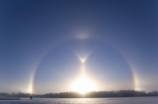 A bright halo can be seen around the sun, taken above the frozen tundra of Finland.