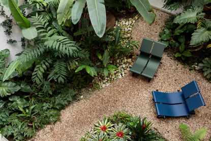 Two lounge chairs by Paulo Mendes Da Rocha in blue and green powder coated aluminium, photographed from above in a tropical garden