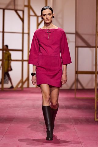 an Hermes model walks the spring/summer 2025 runway in a fuchsia pink look