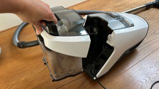 Person removing the bin on the Miele Blizzard CX1 canister vacuum