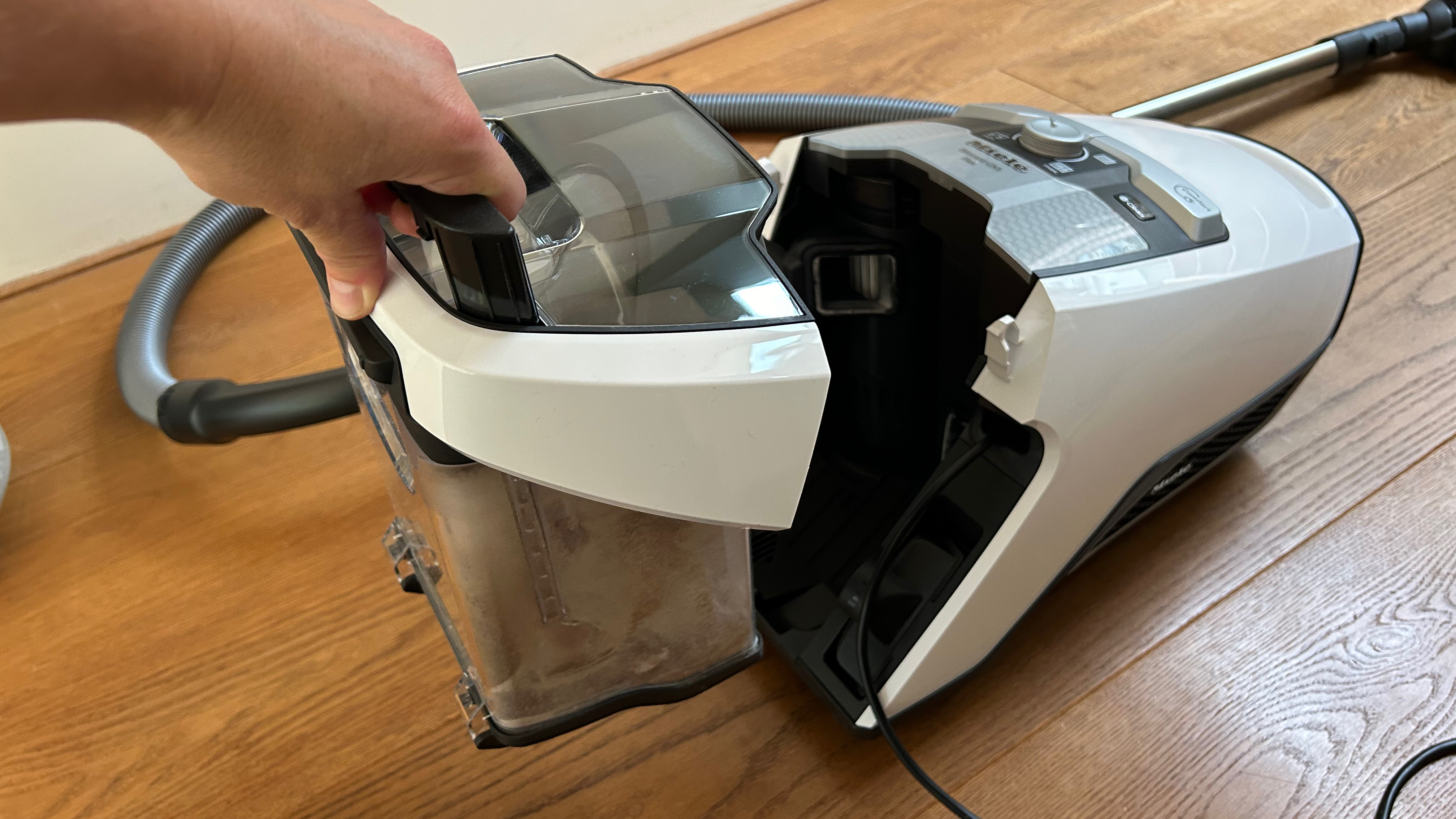 Person removing the bin on the Miele Blizzard CX1 canister vacuum