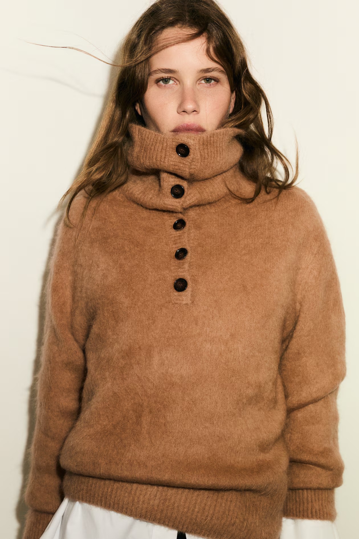 Woman wears beige funnel-neck mohair-blend jumper