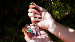 person with rainbow watercolor nails