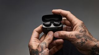 Bowers & Wilkins Pi8 in black finish held in tattooed hands