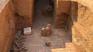 We see the Tomb's courtyard below the ground in an excavation.