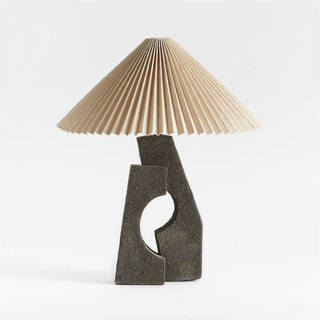 A black sculptural lamp with a white pleated shade.