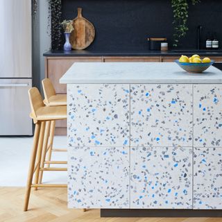 Kitchen island with sides covered in white, blue, purple and grey terrazzo tiles