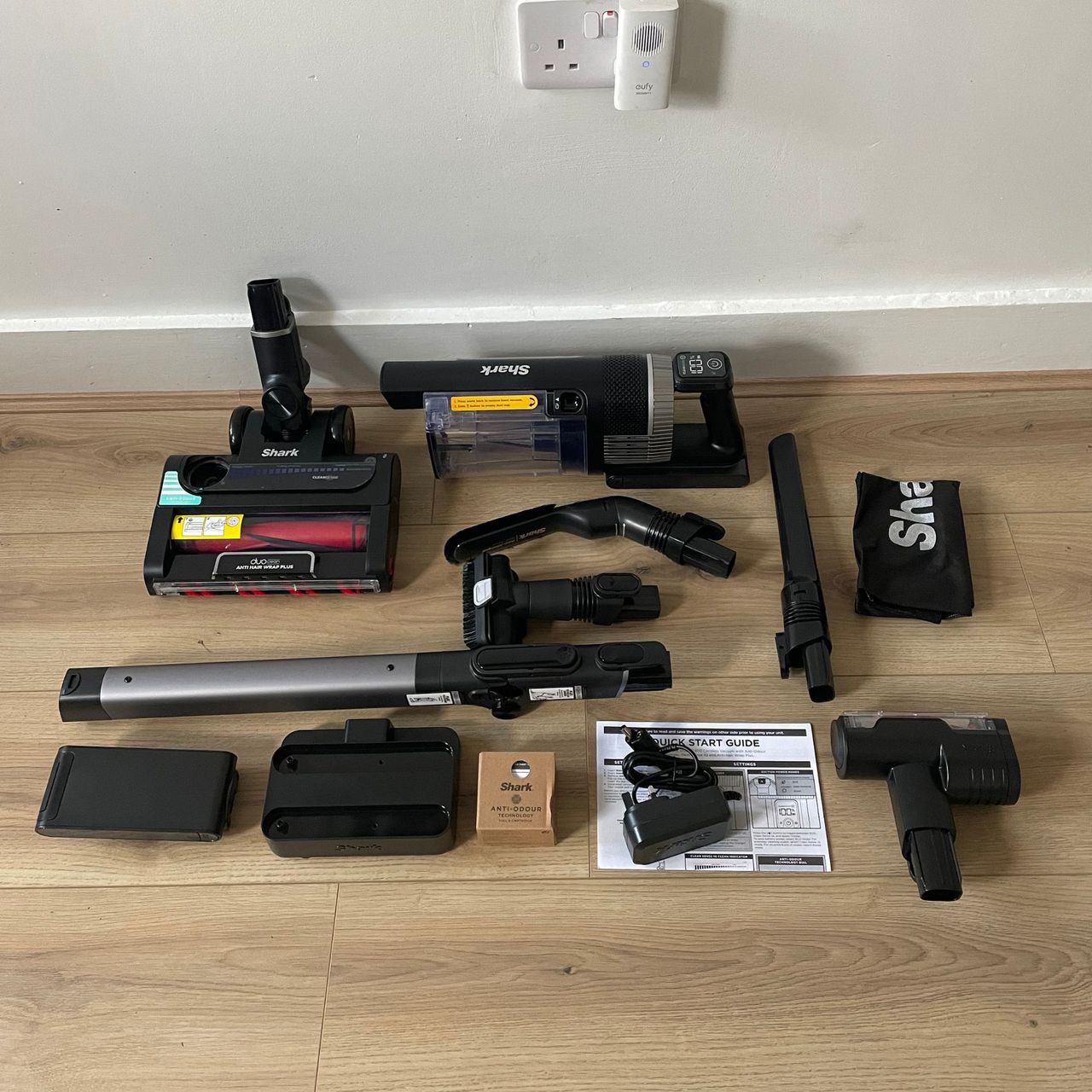 Shark Stratos Cordless Vacuum components laid out on wood-effect flooring