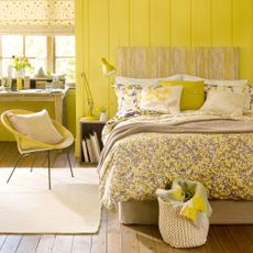 Yellow bedroom with dark wood floors and cream rug