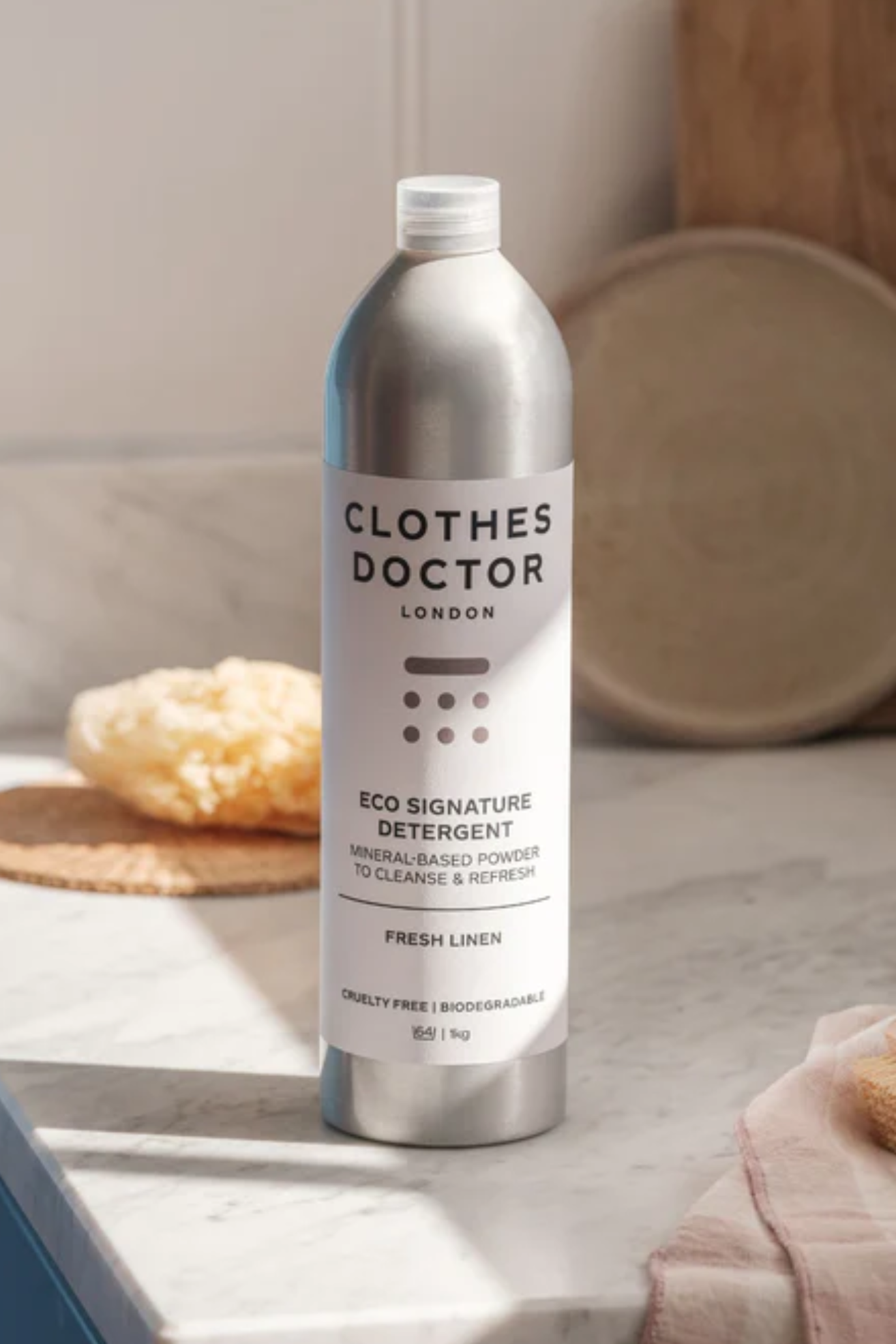 A metal bottle of laundry detergent on a counter