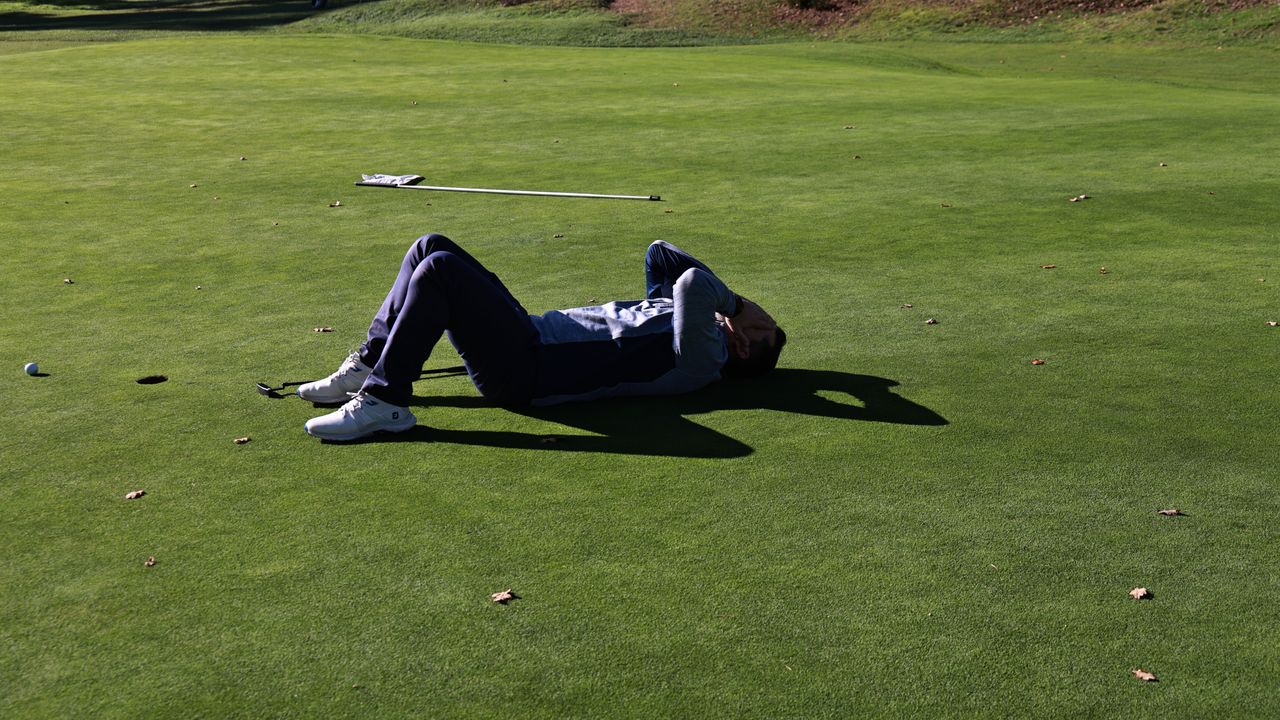 A frustrated golfer reacts to a missed putt