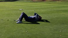 A frustrated golfer reacts to a missed putt