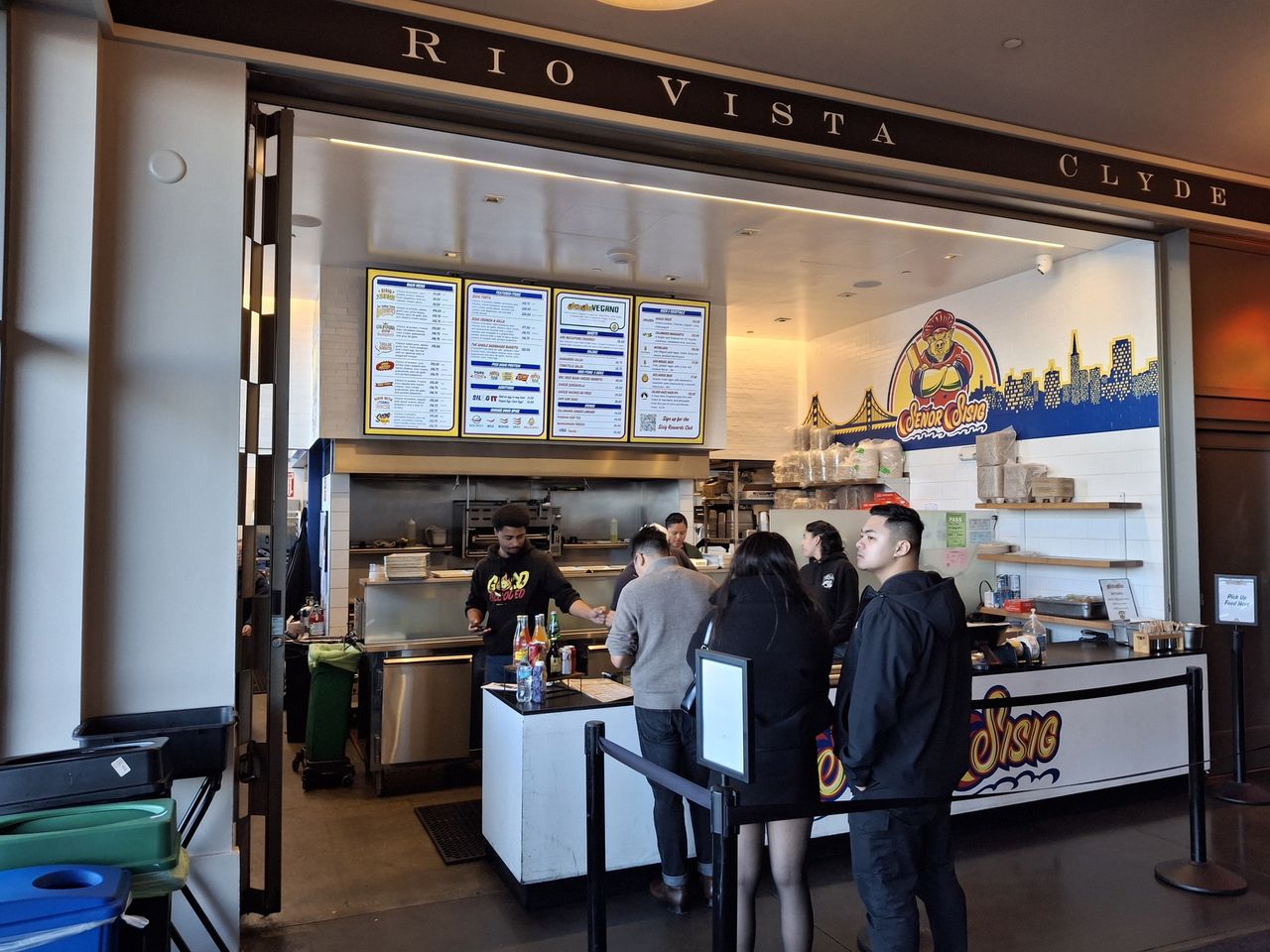 Photo of people lined up a burrito stand indoors shot by Galaxy A35