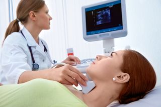 A woman gets an ultrasound of her thyroid gland.