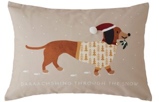 Beige Christmas cushion with picture of dachshund wearing a jersey in snow