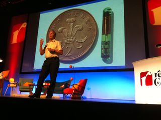 Professor Keith Warwick stands in front of an image of one of the cyber implants in his body.