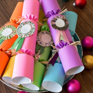 Colourful embellished Christmas crackers in a bowl