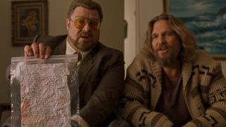 John goodman holding up a piece of paper in a plastic bag, sitting next to Jeff Bridges