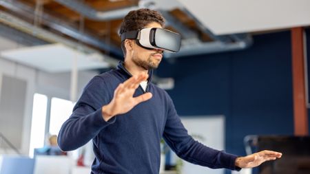 A businessperson wearing an XR or VR headset inside a modern office.