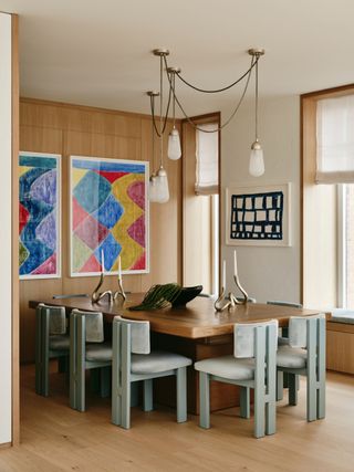 a modern dining room with pale white grey blue chairs around the table