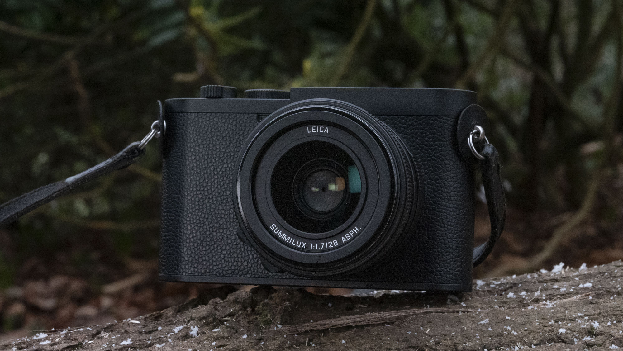 Leica Q3 Monochrom compact camera outside on a snow-dusted log