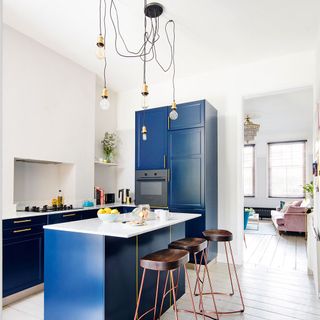 kitchen with blue kitchen cabinets with statement hanging lights