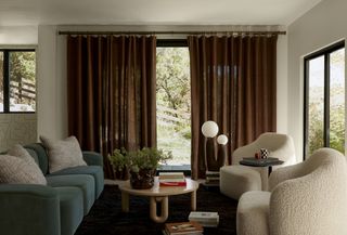 a living room with textured chairs, and dark rust curtains