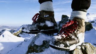 Person's feet wearing hiking boots in the snow