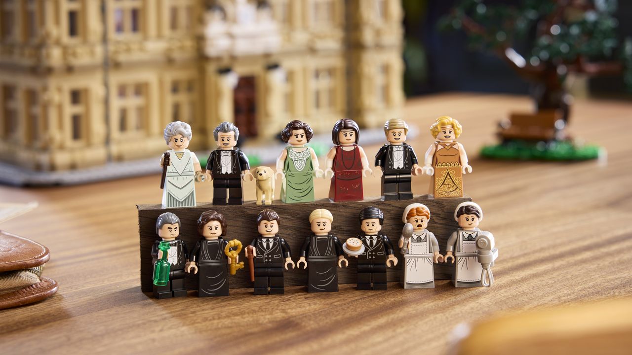 Lego Downtown Abbey minifigures placed in front of the main set, on a wooden surface