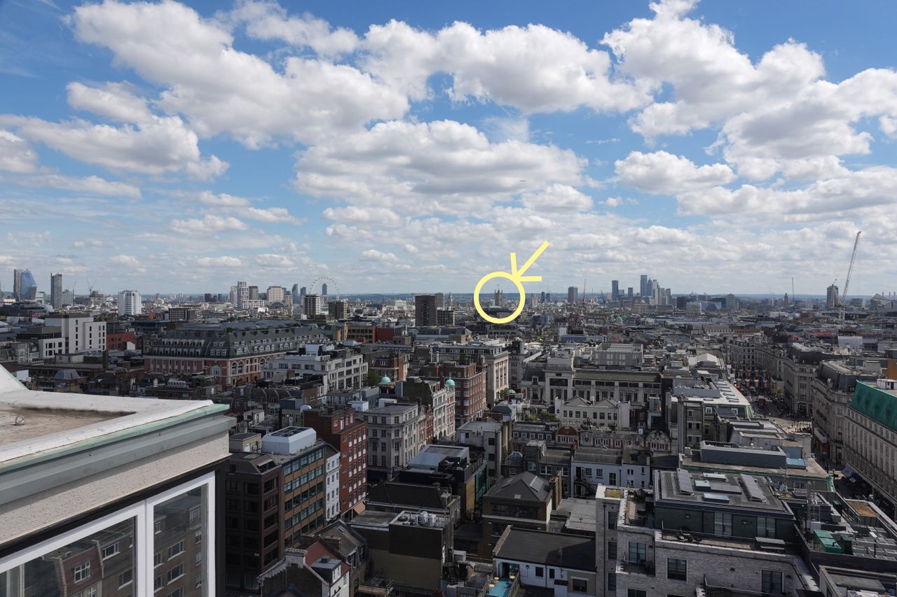 London skyline with a yellow circle and arrow highlighting the distant Elizabeth Tower.