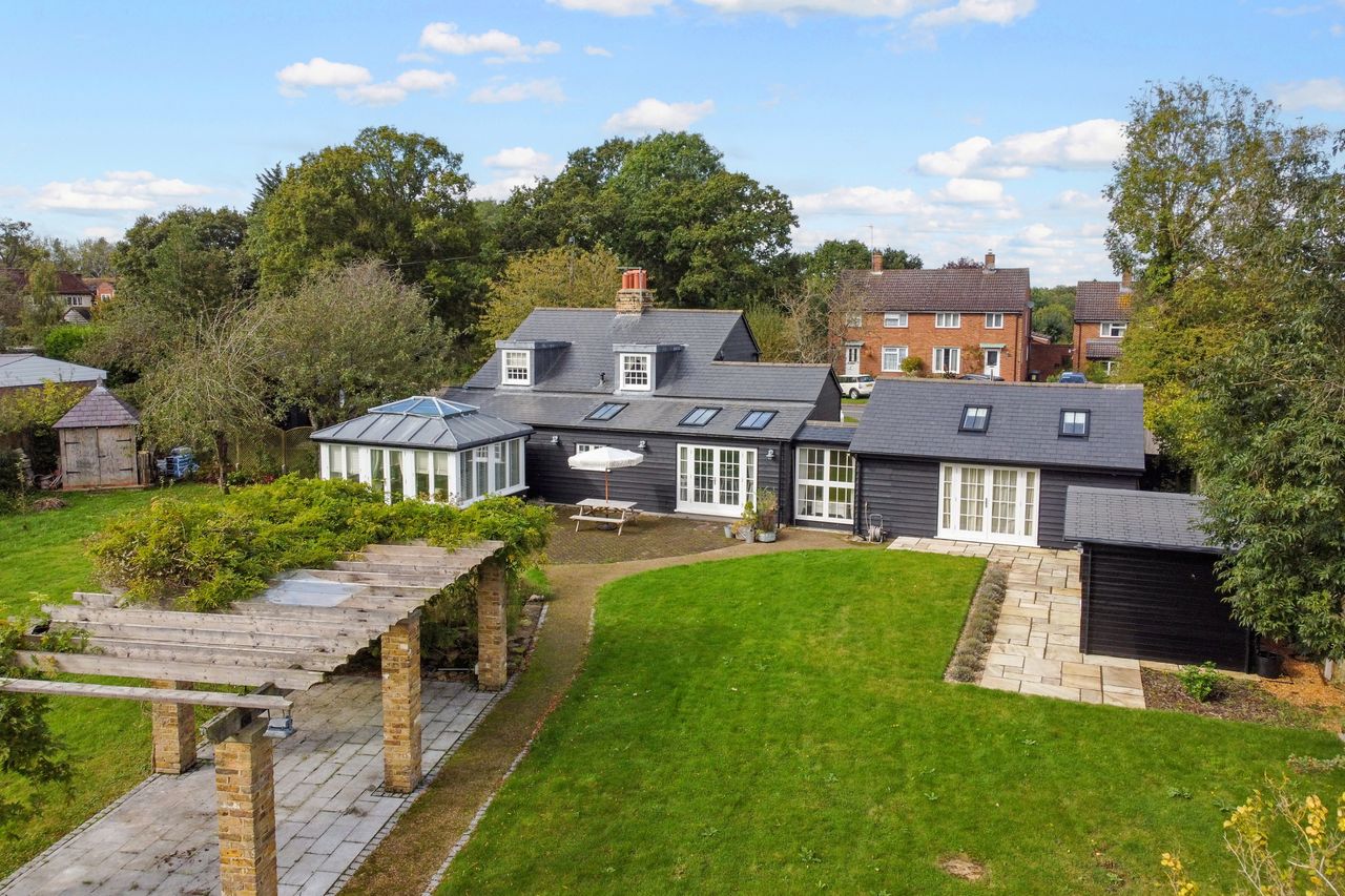 The gardens of Lilac Cottage, with outdoor seating areas and lawn