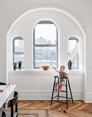 white living room with white trim and baby in a high chair