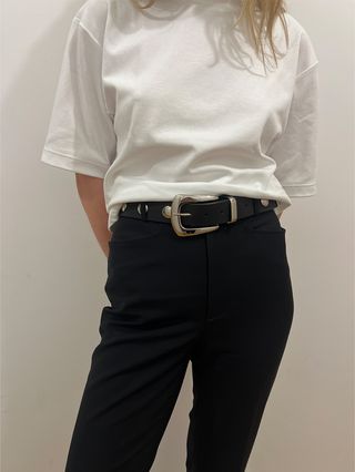White T-shirt worn with black trousers and a black-and-silver studded Western-inspired belt