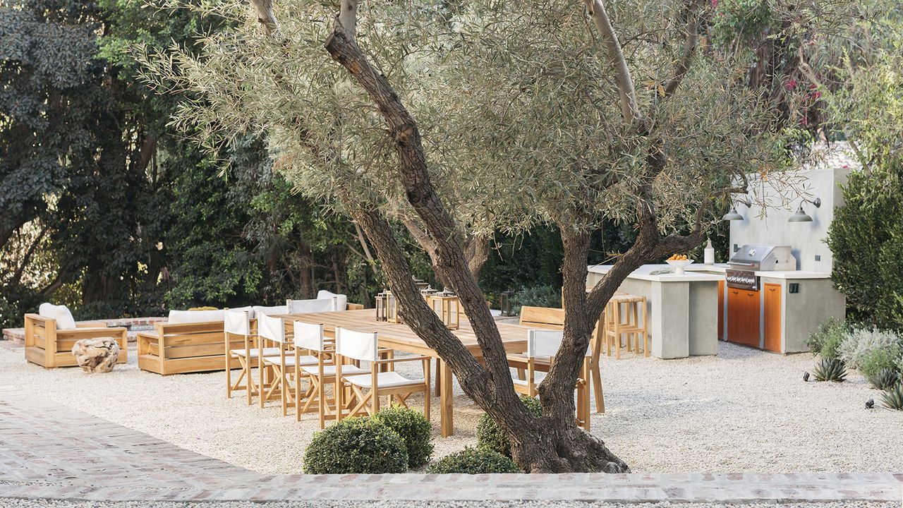 A Mediterranean style backyard with outdoor seating and kitchen area