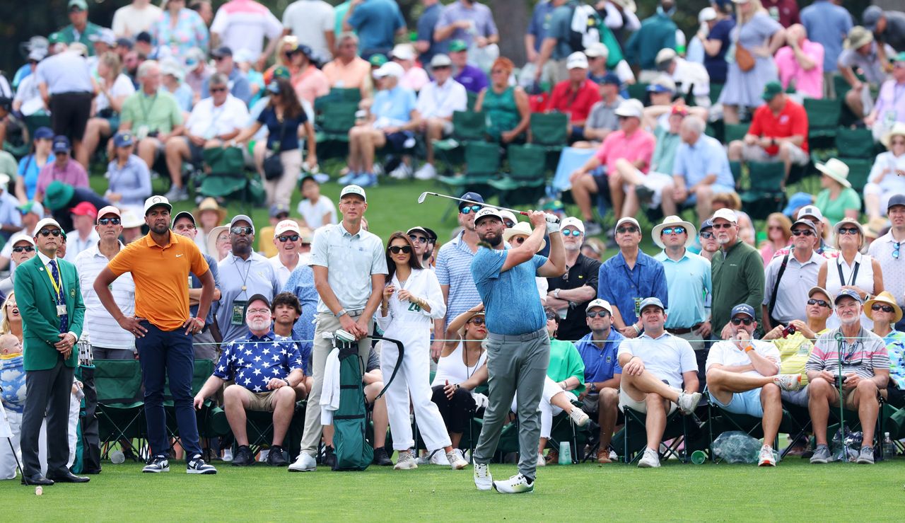 Rahm hits a tee shot whilst the patrons watch on