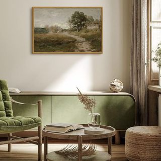 A landscape painting in a living room with a green couch