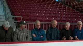 Screenshot of some of the players being interviewed recently forMiracle: The Boys of '80 as they sit on a hockey bench in front of the stands