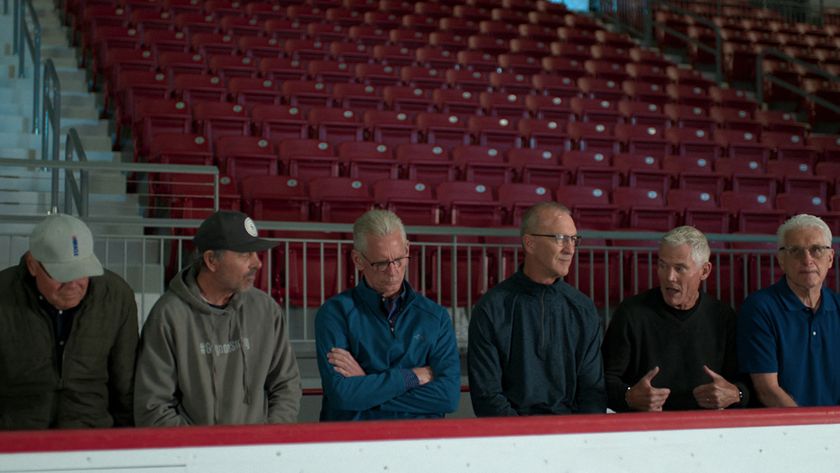 Screenshot of some of the players being interviewed recently forMiracle: The Boys of '80 as they sit on a hockey bench in front of the stands