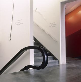 The gallery features barren white walls.