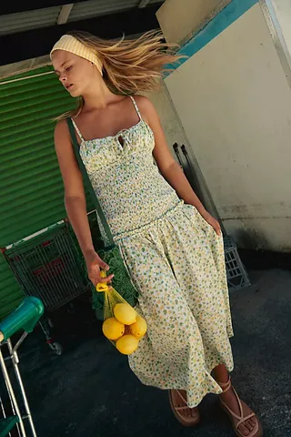 a model wears a floral drop-waist sleeveless dress