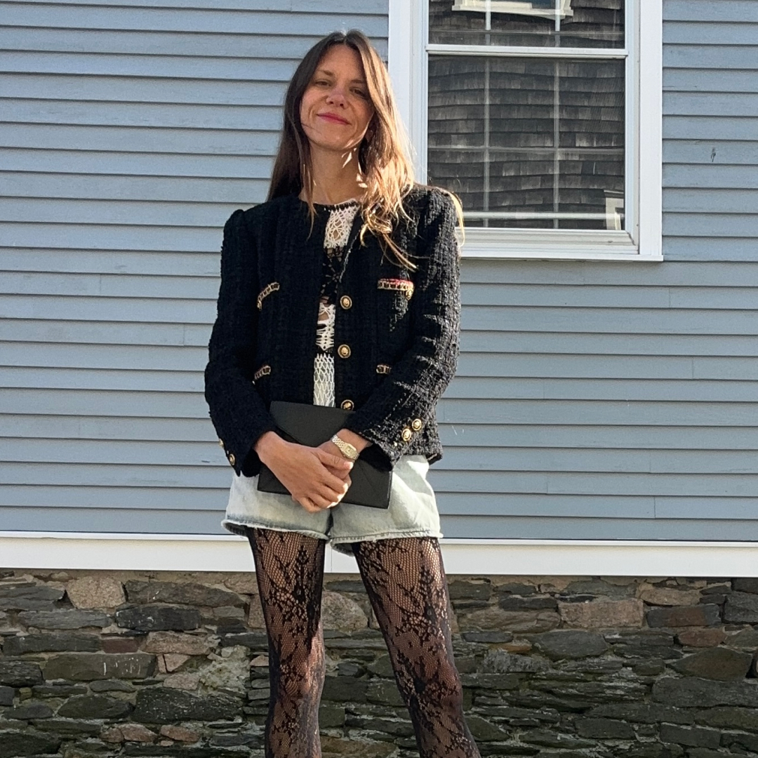 Julia Gall wearing a black tweed blazer, denim shorts, and lace tights