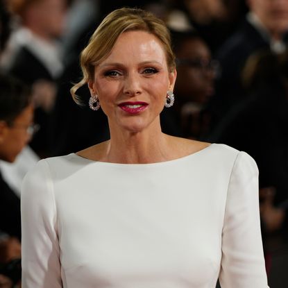 Princess Charlene wearing a white dress and smiling