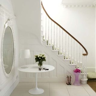 white staircase with brown railing white wall and white tiled flooring