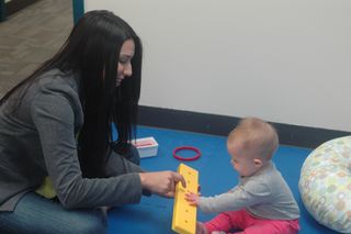 Leticia Martinez, the lab coordinator for the Neurodevelopmental Research Program at the University of Denver, shows an object used in the Bayley Scale, a test of infant cognitive development.