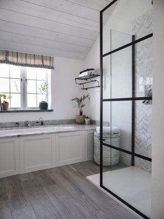White bathroom with cladding ceiling and black metal shower screen in Cornish coastal newbuild